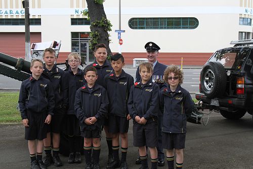 An airforce gentleman poses with boys from Room 14.