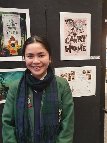 Amelia Chang next to her winning Designs. Book cover for "Carry My Home" and her double page spread.