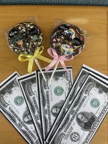 Prizes - "10,000USD" and a matching pair of dinosaur and unicorn chocolate pops!