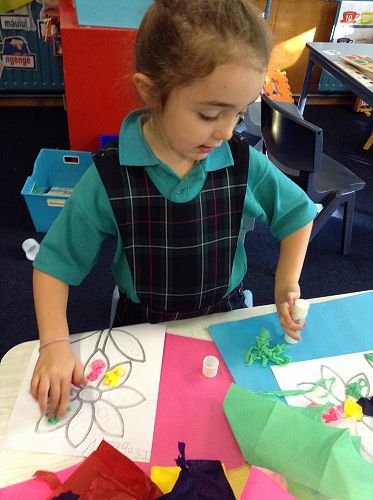 Isobel, one of our talented artists, is tearing and rolling tissue paper to create a work of art.