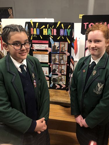 Mariam Reitveld and Samantha Maw stand in front on their project about how static electricity affects different hair types