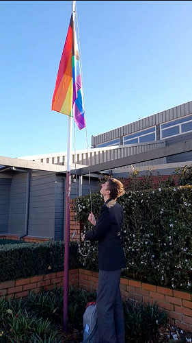 Wyatt Winke raises the Pride flag at HBHS during Pride Week