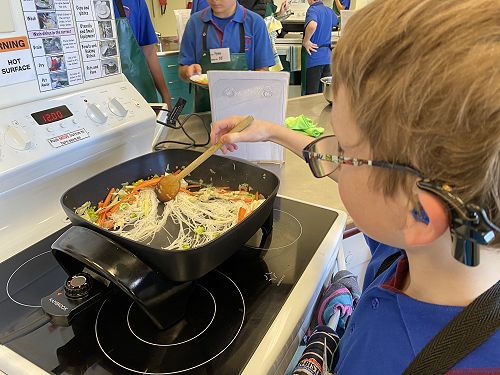 Jordan learning cooking skills during Food Tech