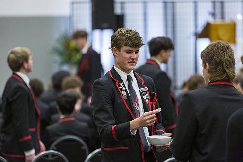 Service: Sam Woodgate hands out communion to fellow students.