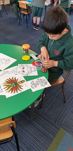 Hugo is making his own dragon using play dough.