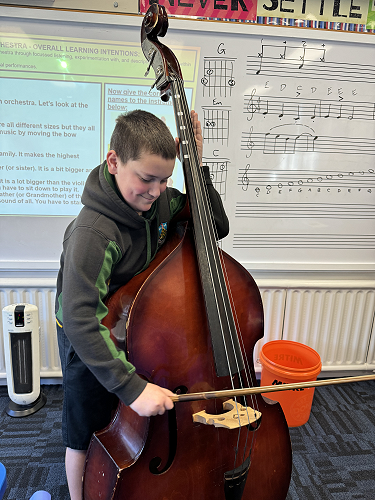 A 7MK student playing the double bass in Year 78 Music class