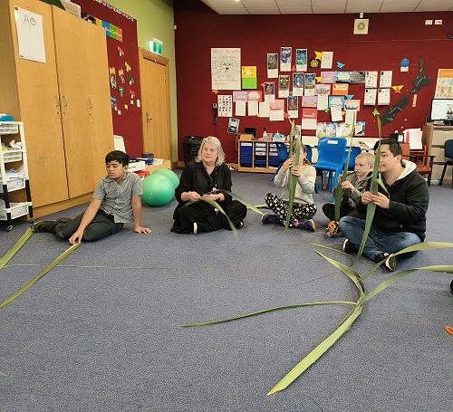 Listening to instructions on how to cut and prepare flax for putiputi