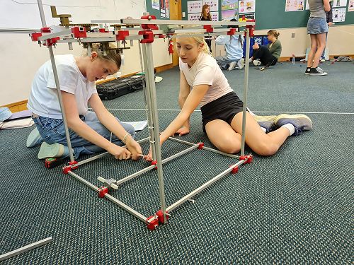 Georgia and Myla tension the springs on their Jack in the Box