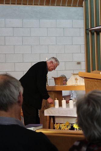 Keith Gover lights a candle