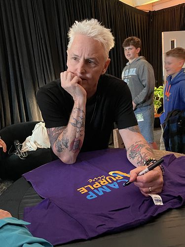 Mike deep in thought about what to write on the Camp Purple T-shirt he signed.