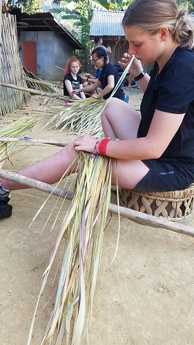 Helping to build thatched roofs in Hoay Fai Village.