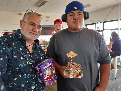 James presented Brooklyn with a prize for his dessert in a pineapple bowl. Adam watching