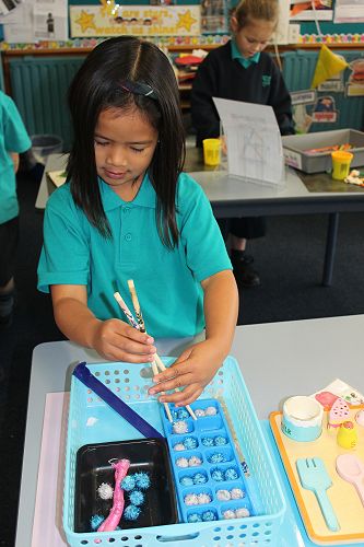 Risha is seen here concentrating hard at the Fine Motor table.