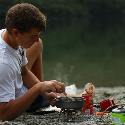 Angus Simmers cooks dinner beside the North Lake.&nbsp;