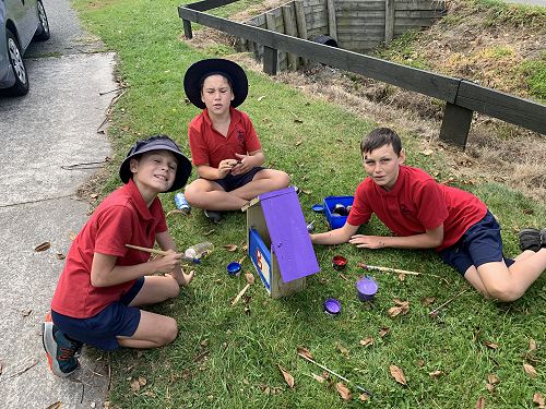 Riwai, Noah and Xion painting their bird feeder