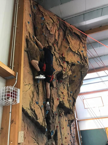 Fletcher climbing the rock wall.
