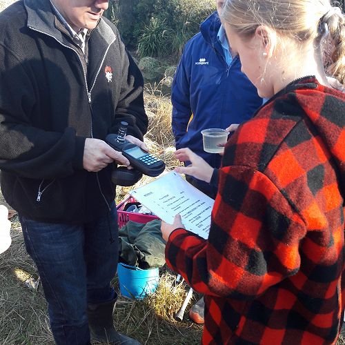 Ella testing water with Chris Konings from Water Watch
