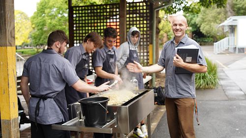Year 12 boys hard at work, prepping for the sausage sizzle