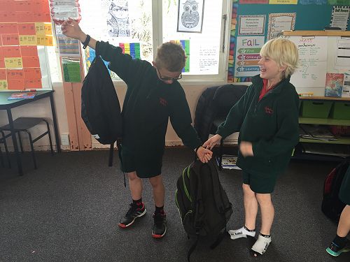 Human scales compare the weight of school bags
