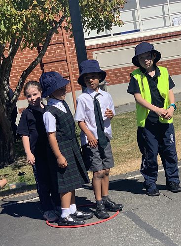PALs leader Charlie French helps Junior School children play the hoop game.