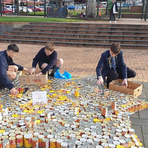 William Blakie, Chris Booyens, and Blake Carter arrange the cans in the Octagon