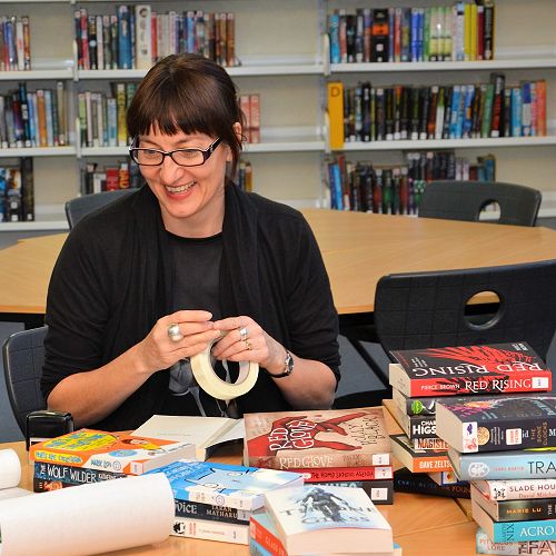 Mrs Vare processing a pile of new editions to our stedily growing fiction section.
