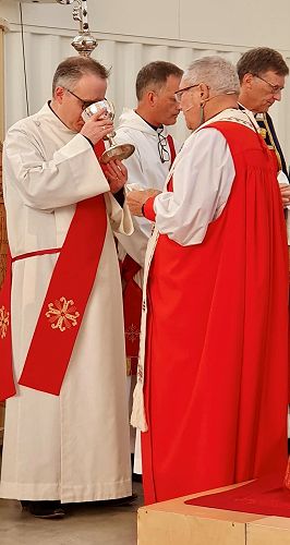 Bishop Richard Wallace giving Rev Dr Andrew Butcher the chalice at his ordination as deacon in July 2023.