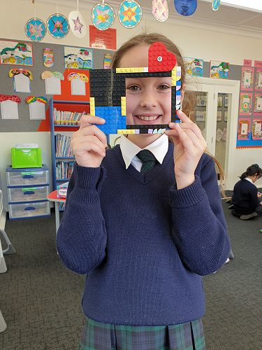 Gabrielle with her photo frame she made with her lego dots